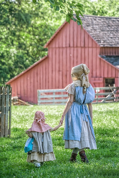 two girls in front of red barn