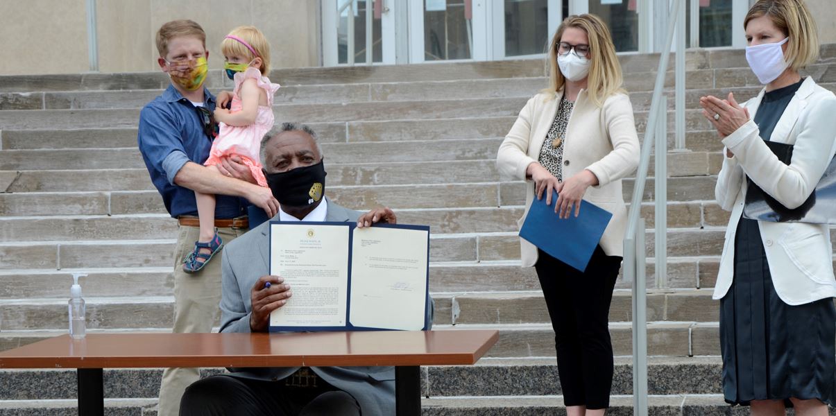 Jackson County Executive Frank White, Jr., signs a new parental leave policy.